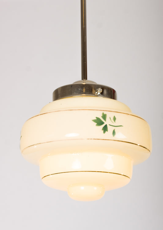 Lampkupa i krämfärgat glas med guldränder och grön lövdekor. 1940-talsdesign