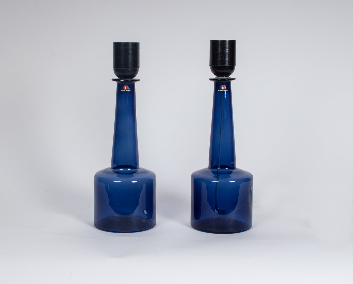 Par eleganta bordslampor i blått glas från finska Iittala, designade av Timo Sarpaneva på 1960-talet.