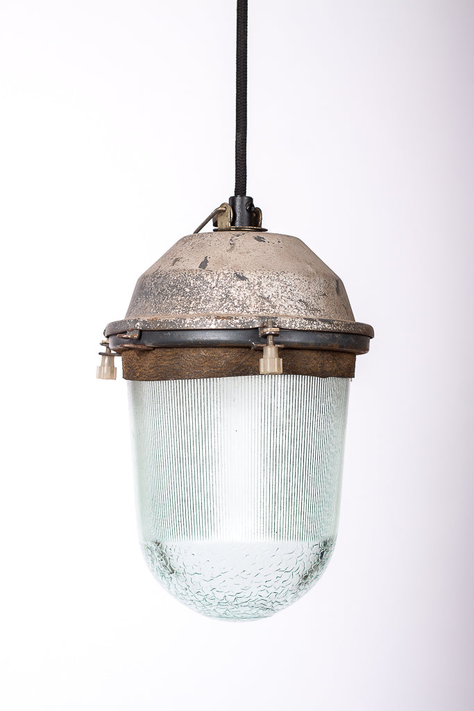 Rå industrilampa med härlig patina på fäste och tjockt glas, monterad med svart textilkabel.