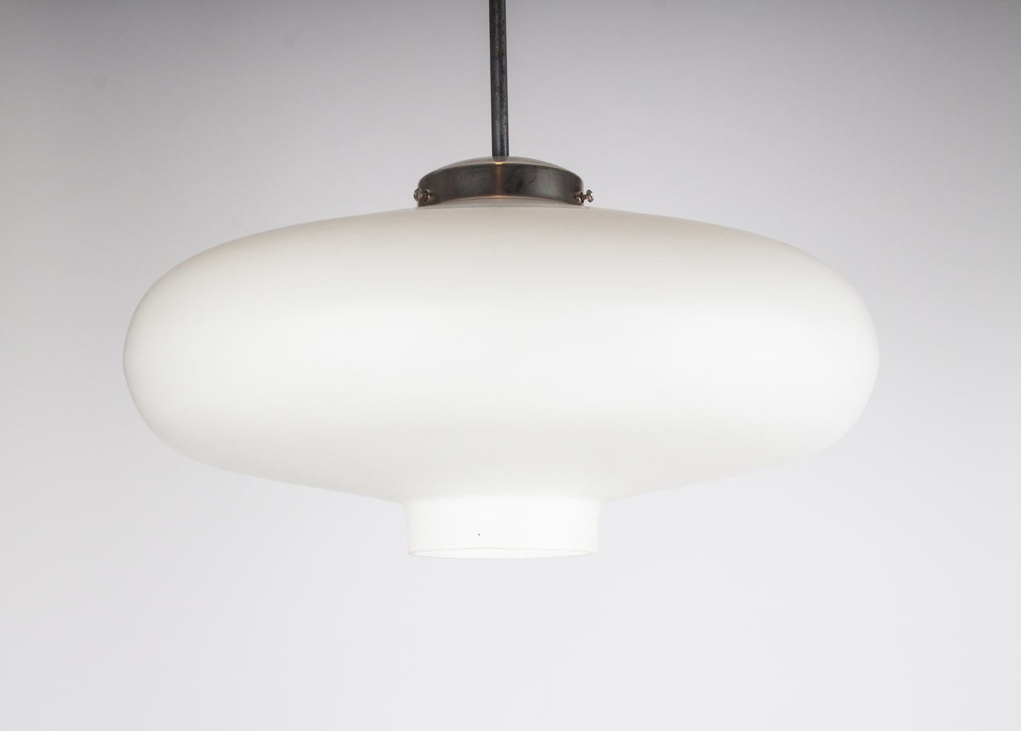 Taklampa i ufoform tillverkad av vitt glas.