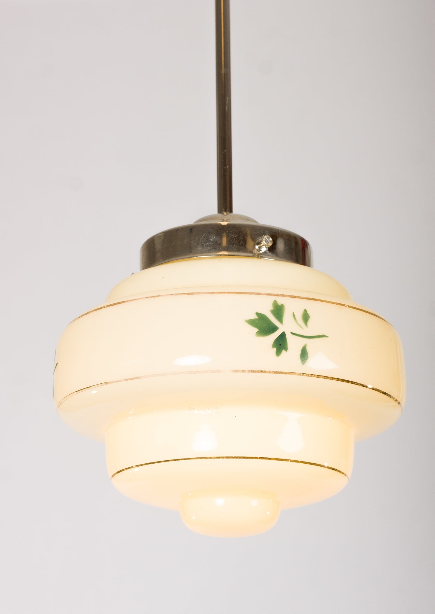 Lampkupa i krämfärgat glas med guldränder och grön lövdekor. 1940-talsdesign
