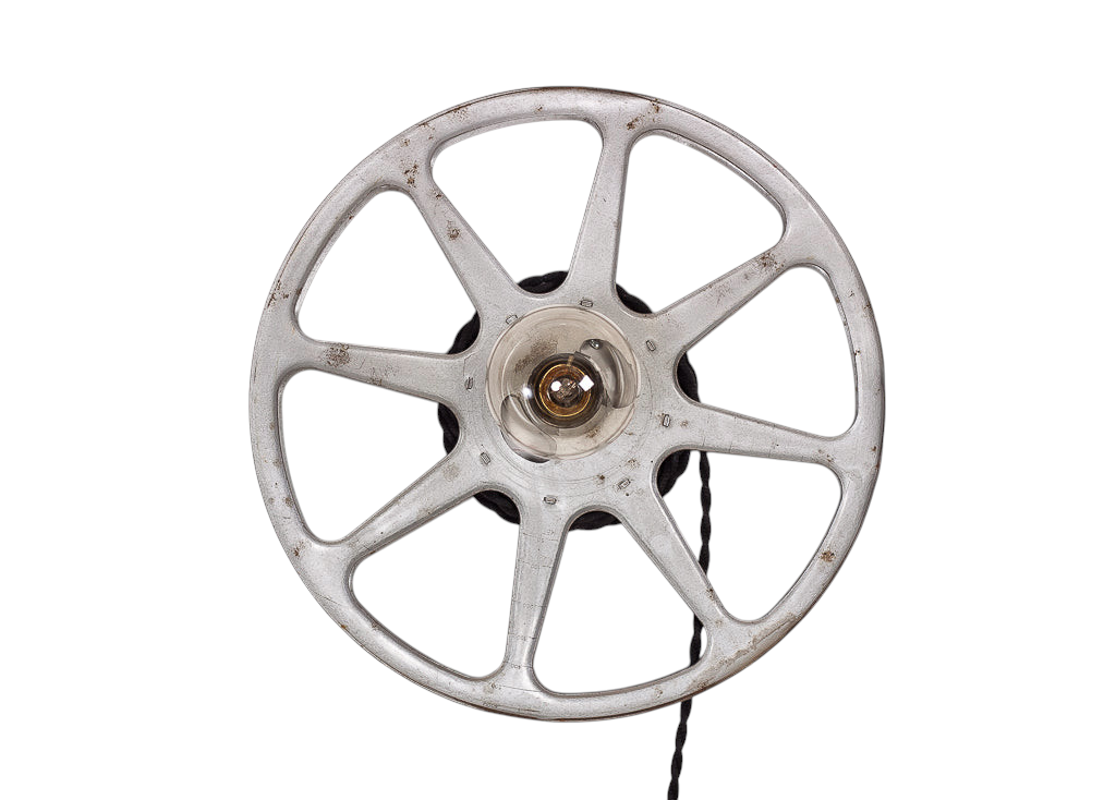 Modighus.se vägglampa formad som en vintage filmrulle i metall med svart tvinnad tygkabel mot vit trävägg