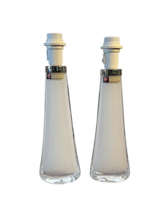 Par eleganta Orrefors bordslampor i vitt glas designade av Carl Fagerlund, säljs hos Modighus.se