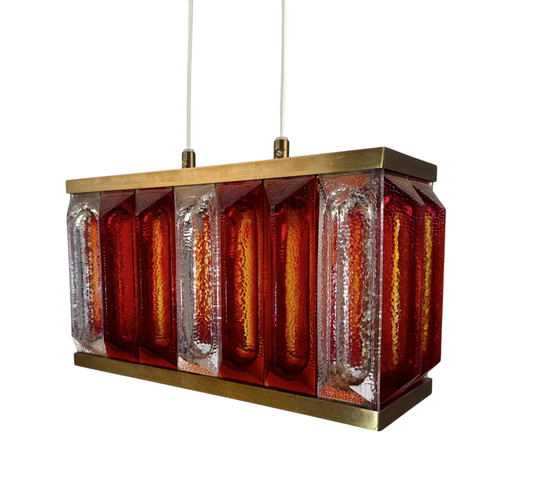 Modighus.se taklampa Prax från Reijmyre i 1970-talsdesign med mässingsstomme och strukturerat rött och klart glas.