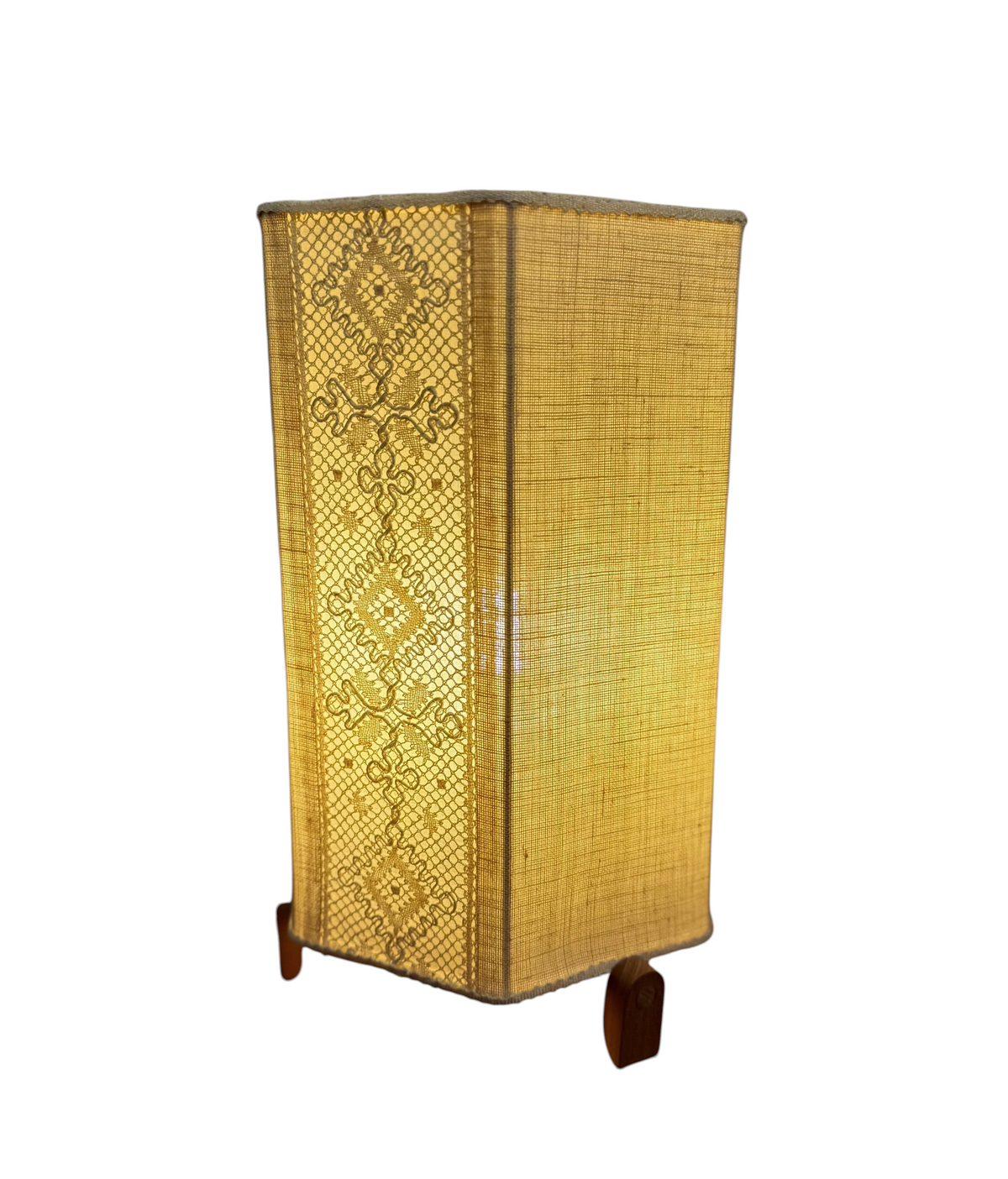 Modighus.se retro bordslampa från 1960-talet med teakfot och beige skärm i virkad textil som ger ett varmt ljus.