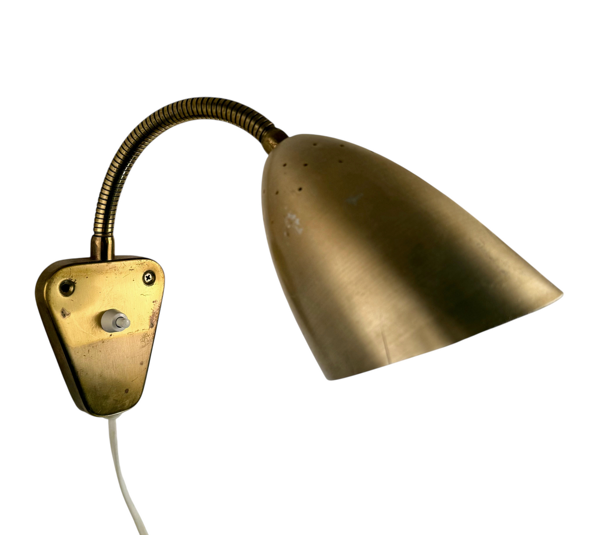 Modighus.se retro vägglampa från 1950-talet med böjbar arm, mässingsbas och perforerad kopparfärgad skärm.