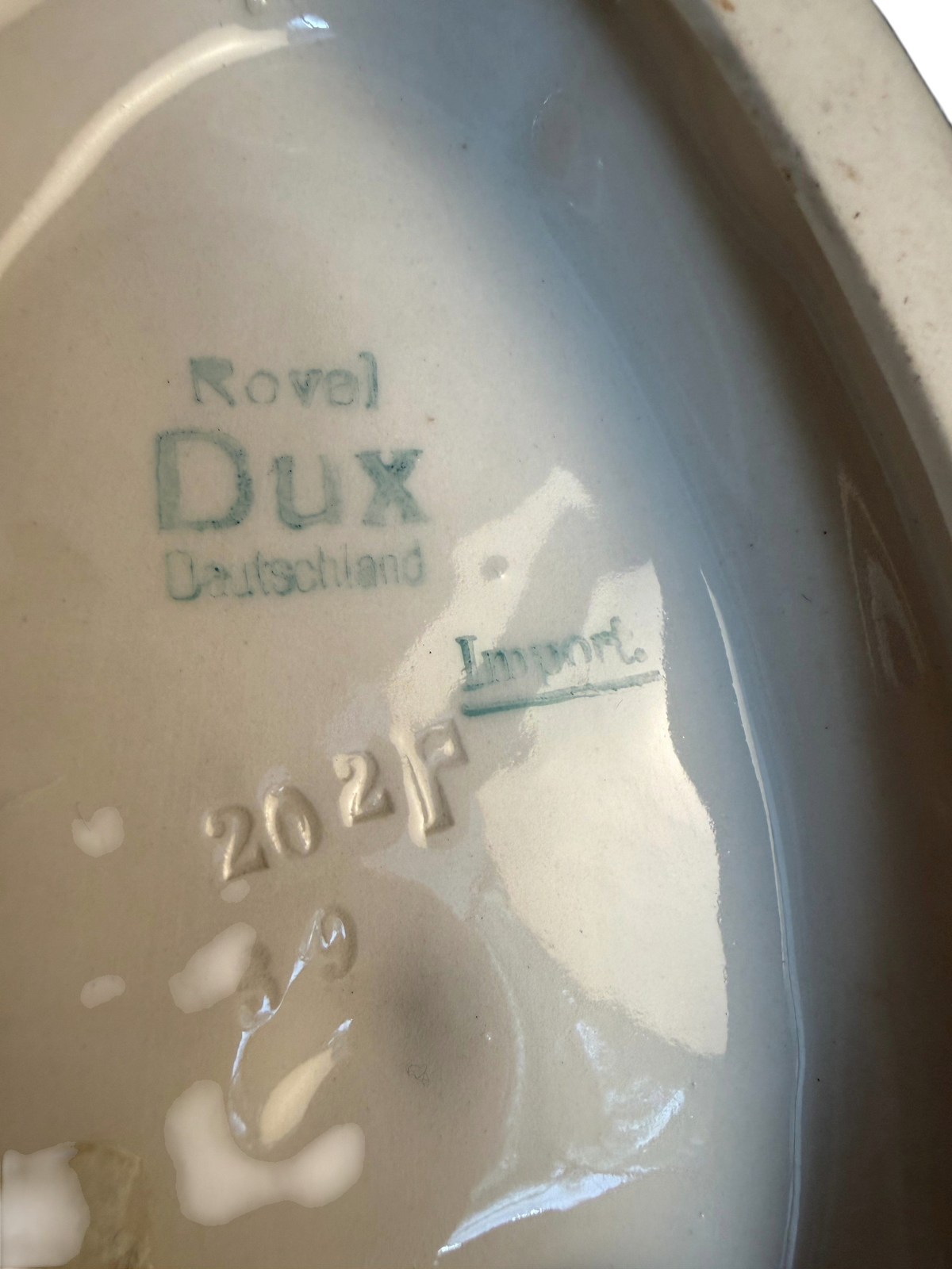 Modighus.se stämpel under Royal Dux porslinsfigur med texten Royal Dux Deutschland och modellnummer 2027