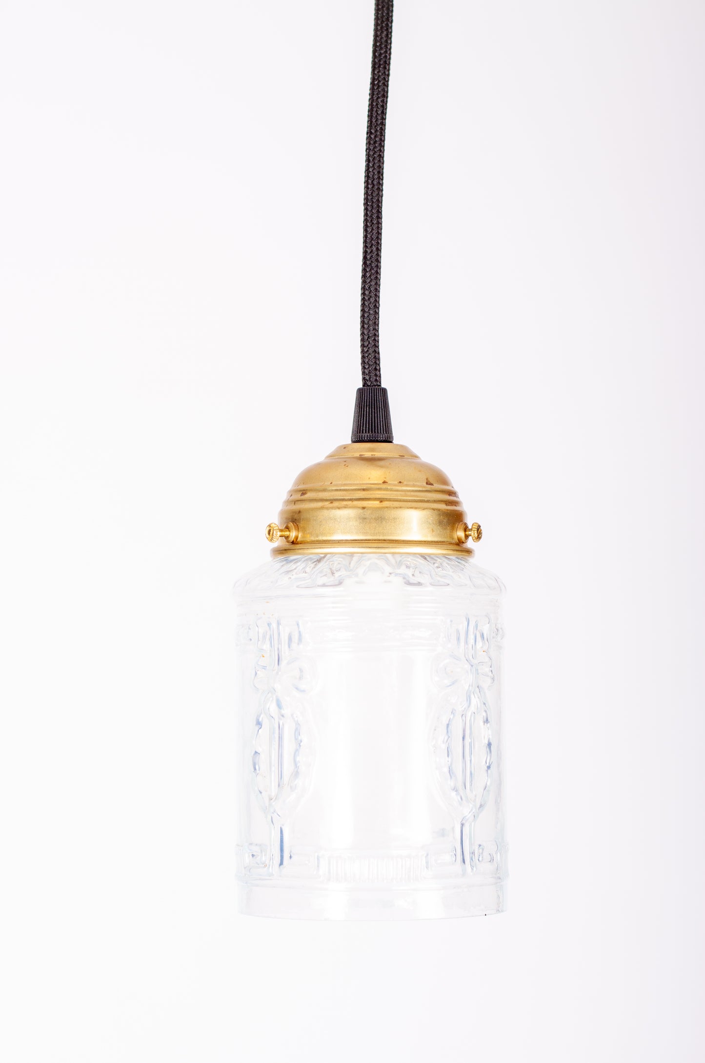 Fönsterlampa i mjölkvitt pressat glas med mässingsfäste och svart rund textilkabel, 1930-tal
