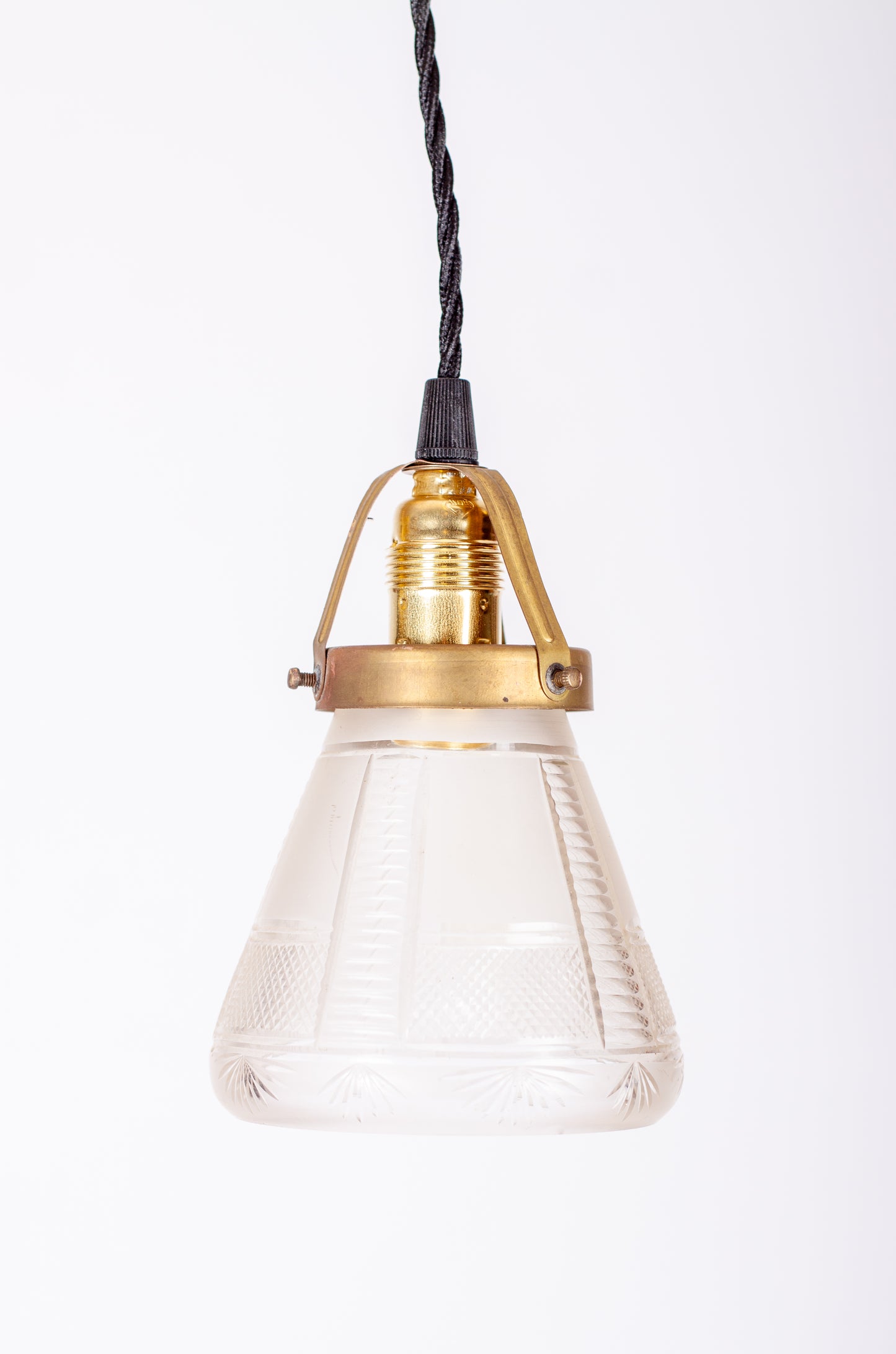 Fönsterlampa med kupa i mönstrat pressglas, mässingsfäste och E14-sockel med svart tvinnad kabel, 1920-tal
