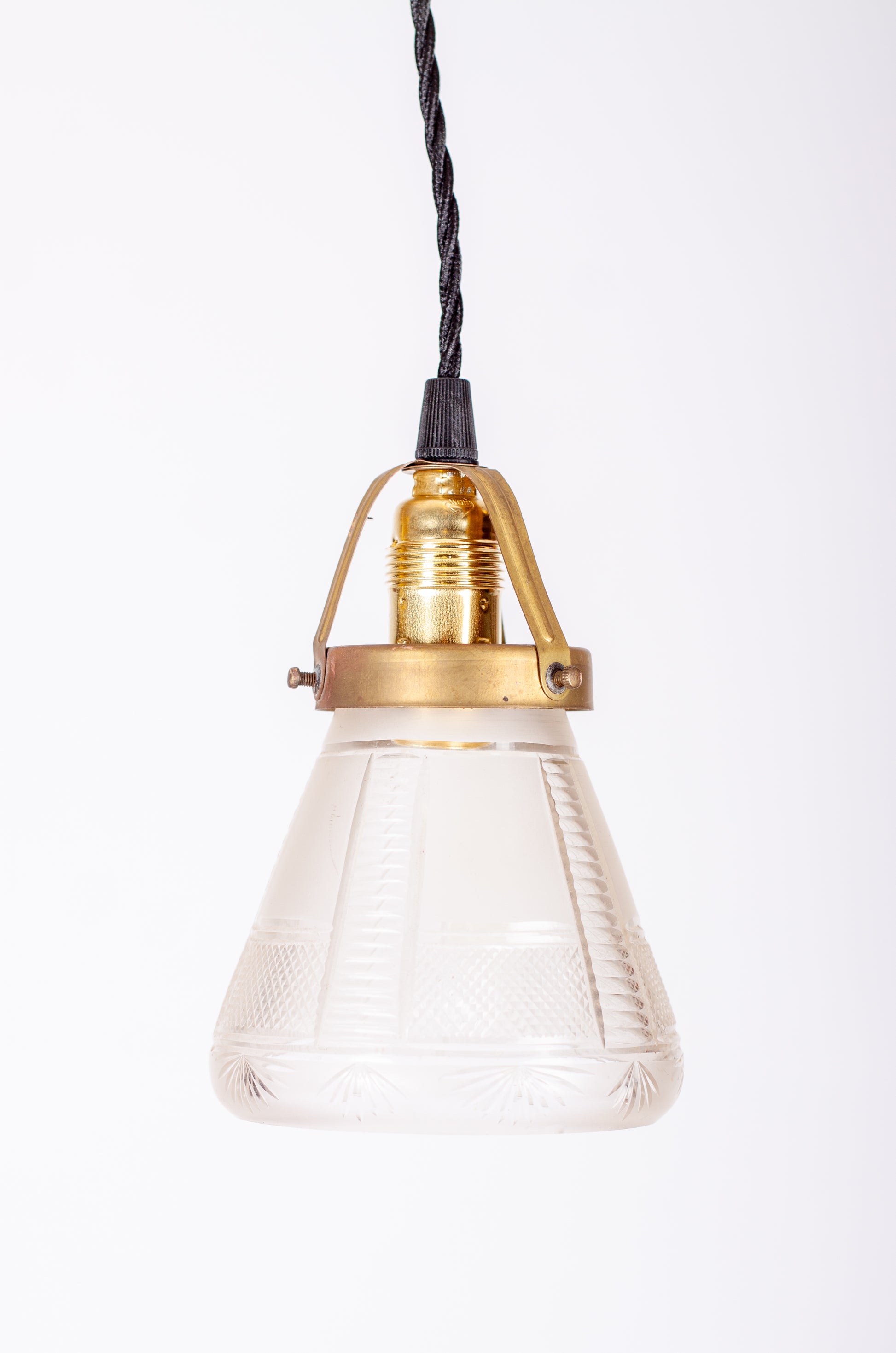 Fönsterlampa med kupa i mönstrat pressglas, mässingsfäste och E14-sockel med svart tvinnad kabel, 1920-tal
