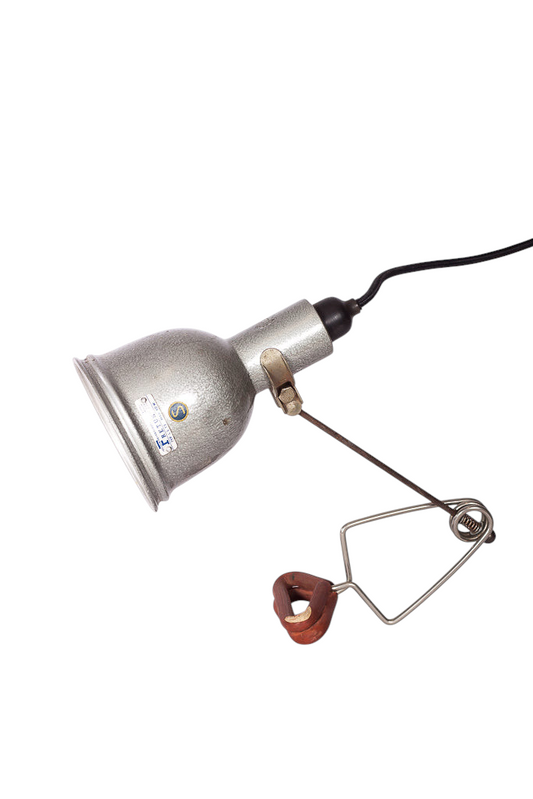 Klämlampa i metall monterad med svart rund textilkabel.