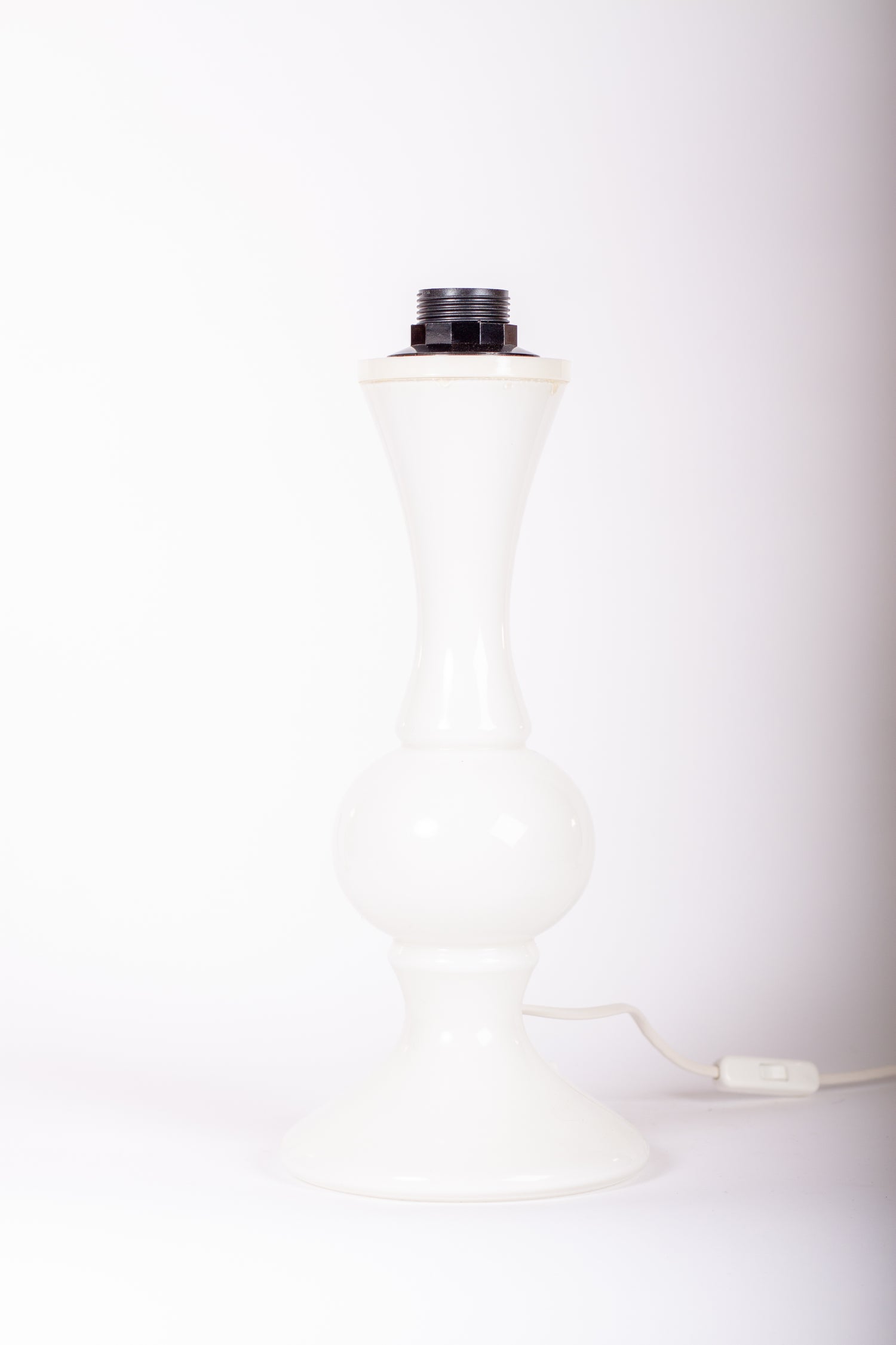 Lampfot i vitt glas av Luxus Vittsjö, designad av Uno och Östen Kristiansson.
