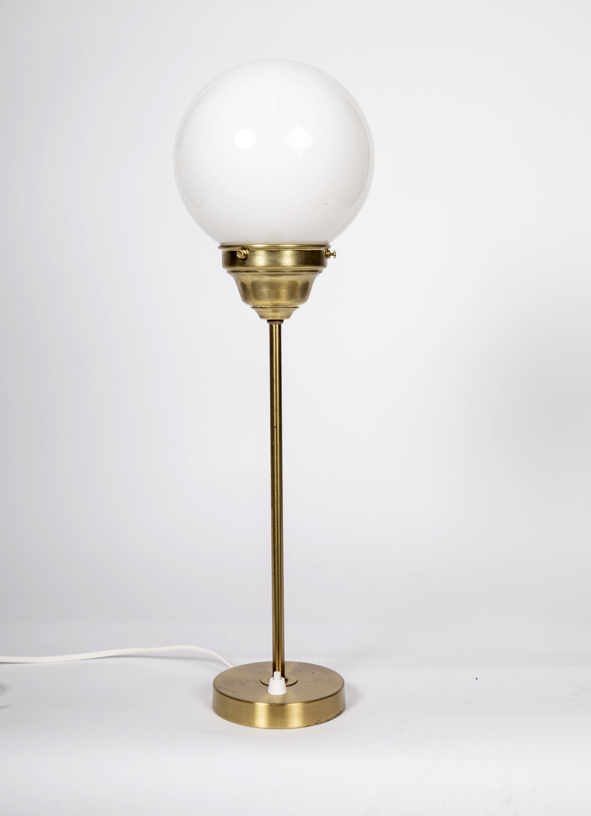 Elegant bordslampa i mässing med rund glob i vitt glas
