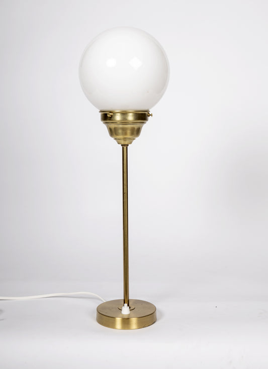 Elegant bordslampa i mässing med rund glob i vitt glas
