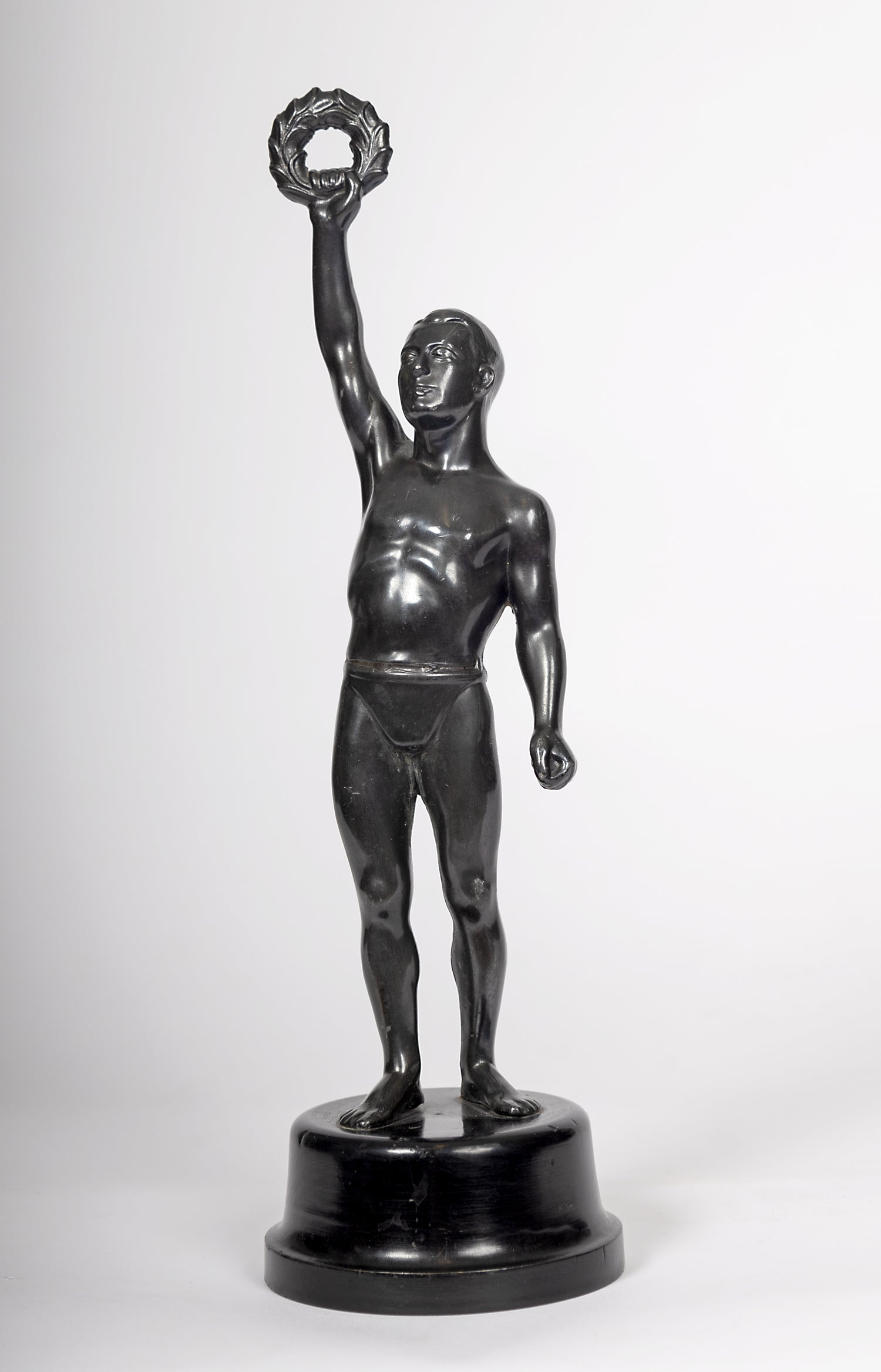 Dekorativ statyett i metall monterad på träsockel
