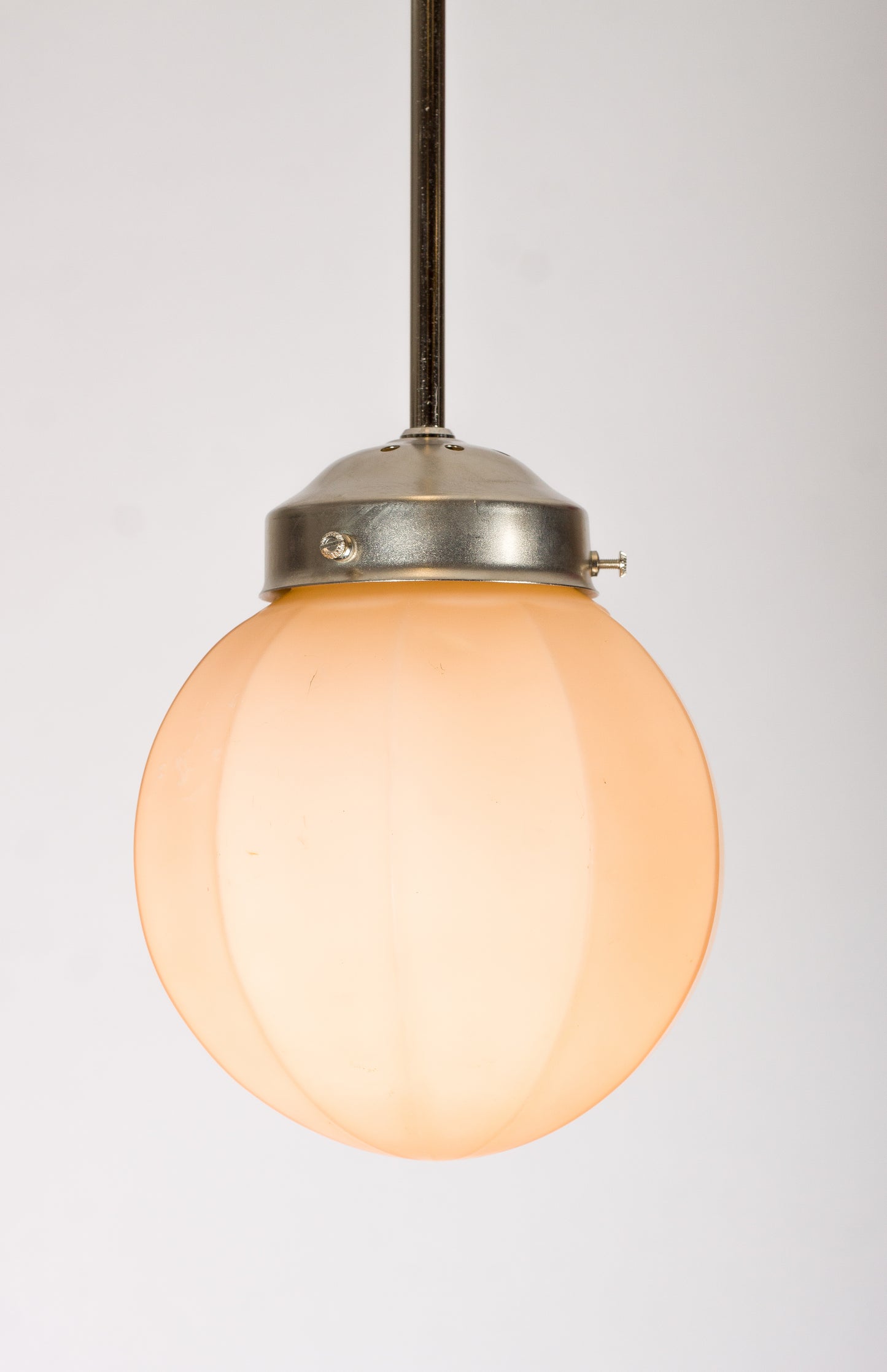 Mindre glaskupa i mjuk orange‑rosa marmorerad ton. Vintage pendelkupa som kan monteras med pendel i nickel, krom, mässing eller textilkabel.