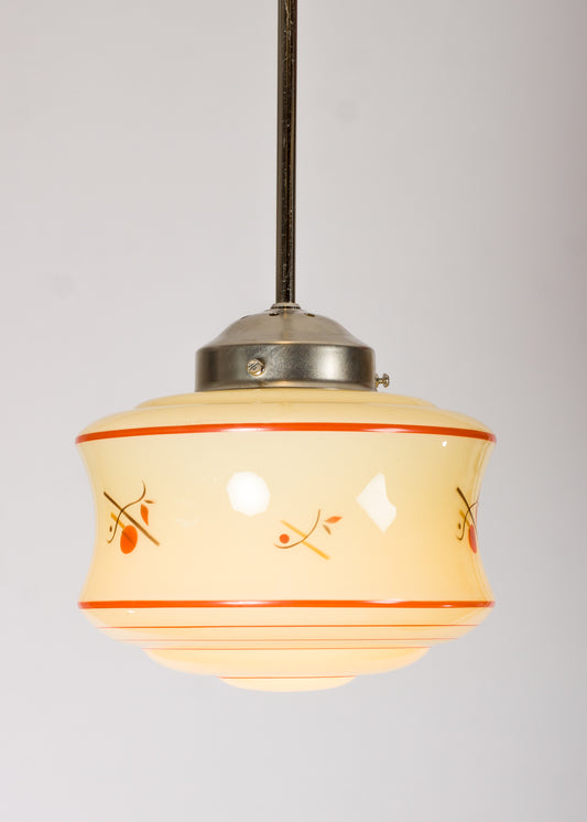 Retro lampkupa i gult glas med röda dekorränder och motiv
