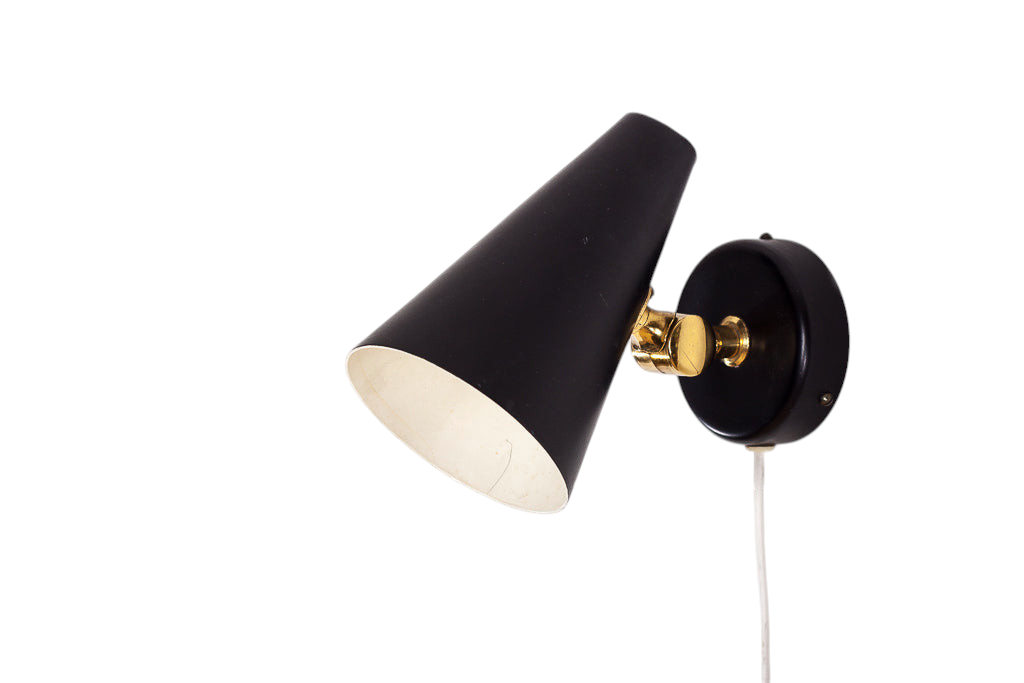 Stilren retro vägglampa i svart metall med detaljer i mässing.