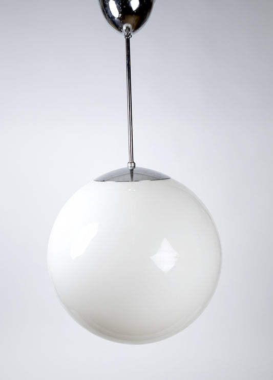 Stor klotformad pendellampa av klassisk skolglob-modell i vitt glas med metallpendel, 1970–1980-tal
