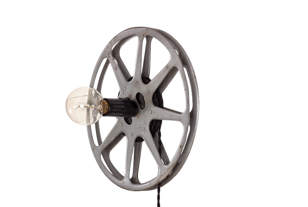 Unik vägglampa formad som en gammal filmrulle med svart tvinnad tygkabel.