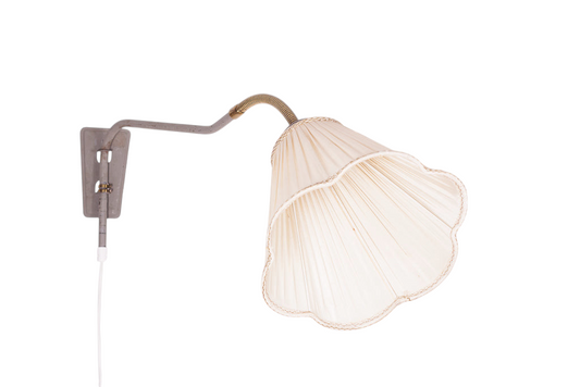 Vägglampa med gråmålad stomme och detaljer i mässing