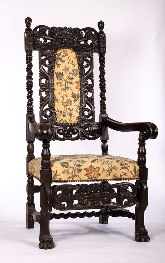 Stor tron-karmstol i mörkt trä med vackert utskurna detaljer
