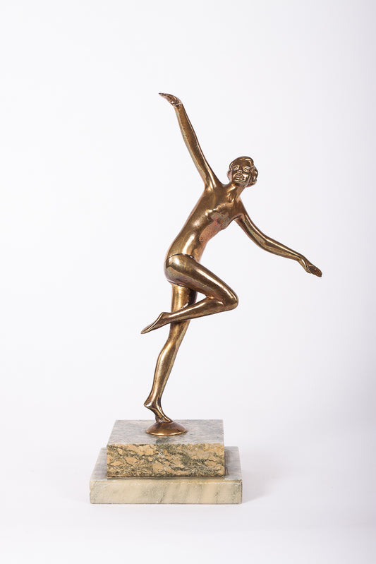 Art Deco-statyett föreställande en dam, i mässing på fot av stenmaterial, märkt Dansk Kunst. 
