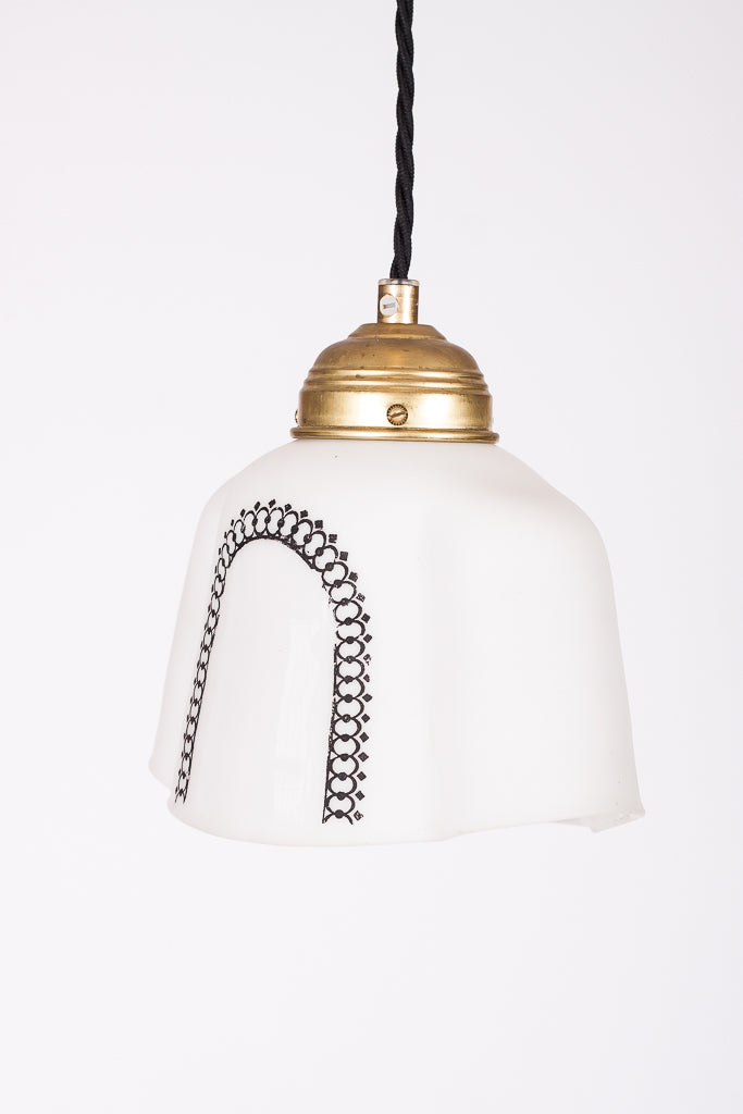 Liten taklampa och fönsterlampa i vitt glas med svart kransmotiv, mässingsfäste och svart tvinnad textilkabel. Svensk design.

