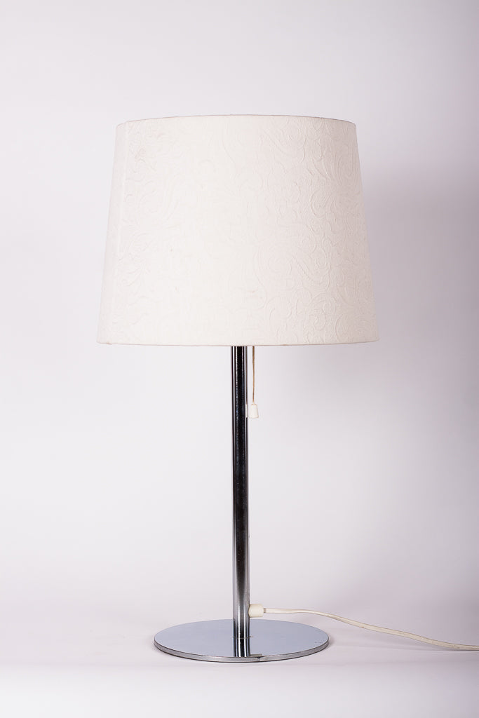 Stilren bordslampa med kromad fot från Luxus Vittsjö, designad av Uno och Östen Kristiansson.
