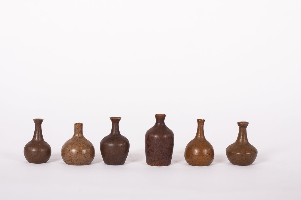 Samling med sex keramikvaser i miniatyr, varierande form och glasyr
