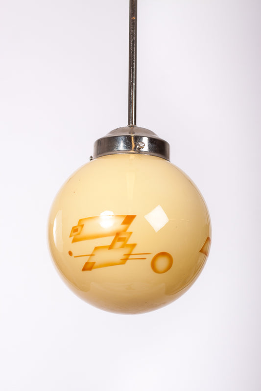 Ljusbrun pendelkupa med brun Art Deco-dekor. Pendel i nickel eller mässing.
