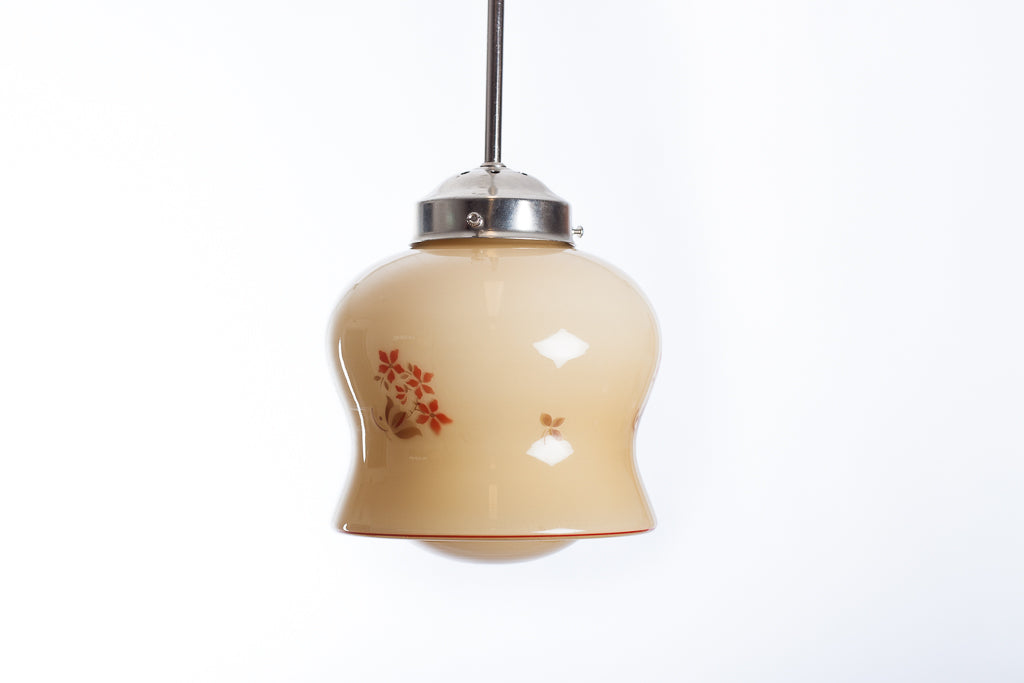 Krämfärgad glaskupa med brun och orange växtdekor. Vintage pendelkupa som kan monteras med pendel i nickel, krom, mässing eller textilkabel.
