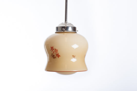 Krämfärgad glaskupa med brun och orange växtdekor. Vintage pendelkupa som kan monteras med pendel i nickel, krom, mässing eller textilkabel.