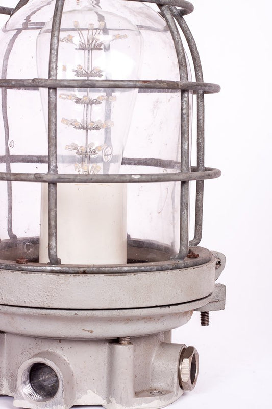 Industrilampa i metall och glas från Sieverts Kabelverk, monterad som bordslampa med svart textilkabel och strömbrytare.
