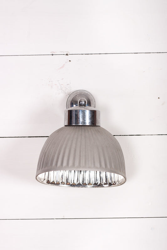 Vägglampa i fattigmanssilver och glas.
