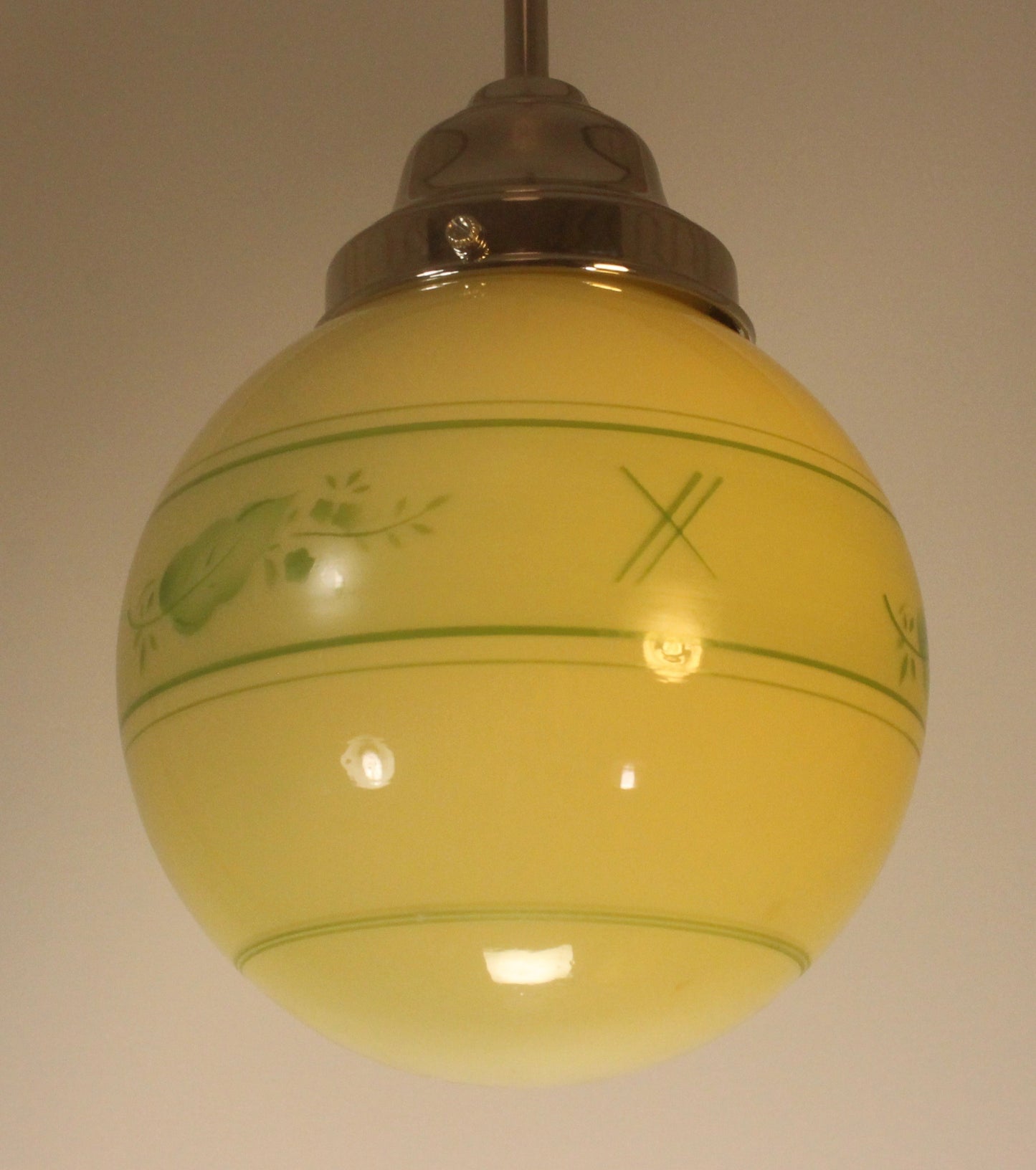 Liten gul lampkupa med grön dekordetalj, 1940-tal, diameter ca 15 cm, krom- eller mässingspendel
